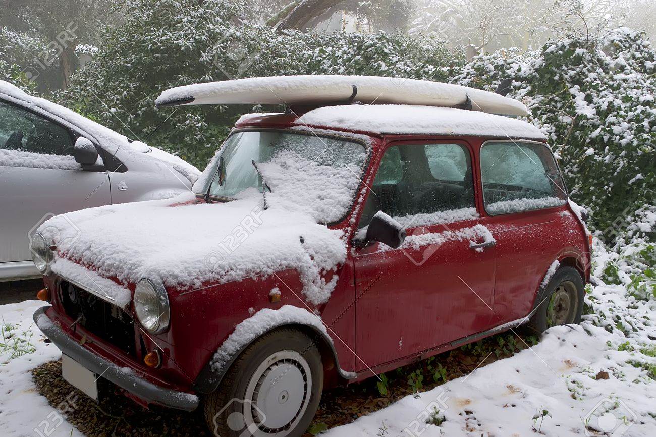 12616278-surfboard-on-a-car-roof-covered-by-snow-Stock-Photo