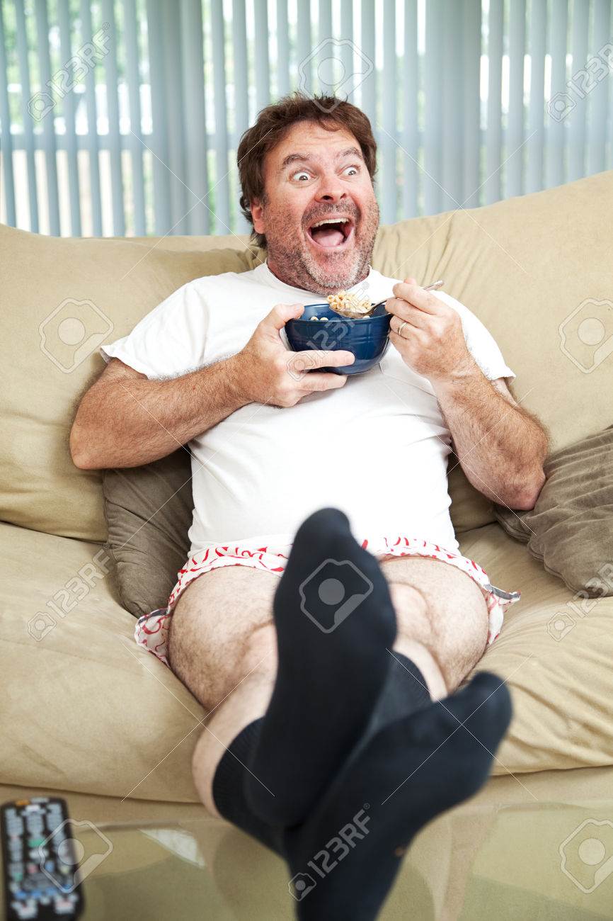37126500-Middle-aged-man-in-his-underwea-watching-TV-and-eating-cereal-He-s-laughing-at-what-s-on-te
